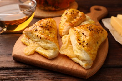 Fresh delicious puff pastry with cheese on wooden table, closeup