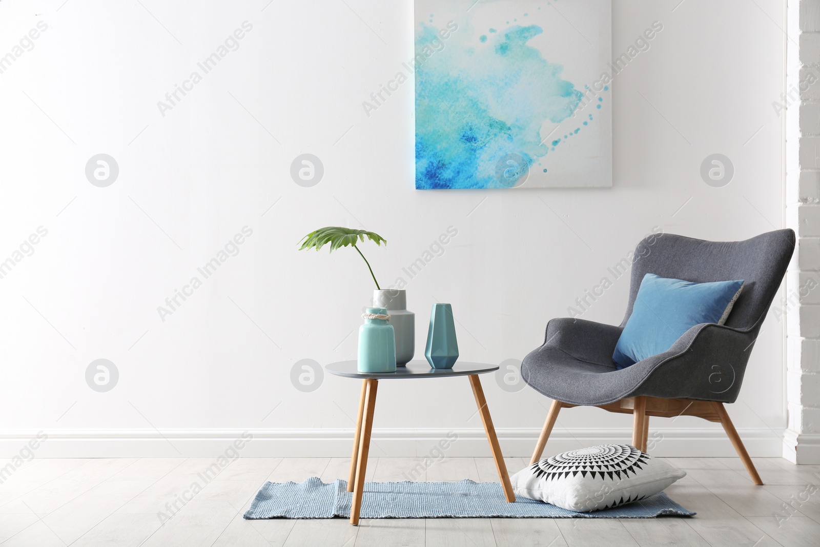 Photo of Living room interior with vases on table and armchair near white wall. Space for text