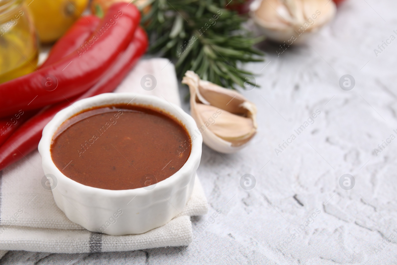 Photo of Fresh marinade and different ingredients on light grey textured table, closeup. Space for text