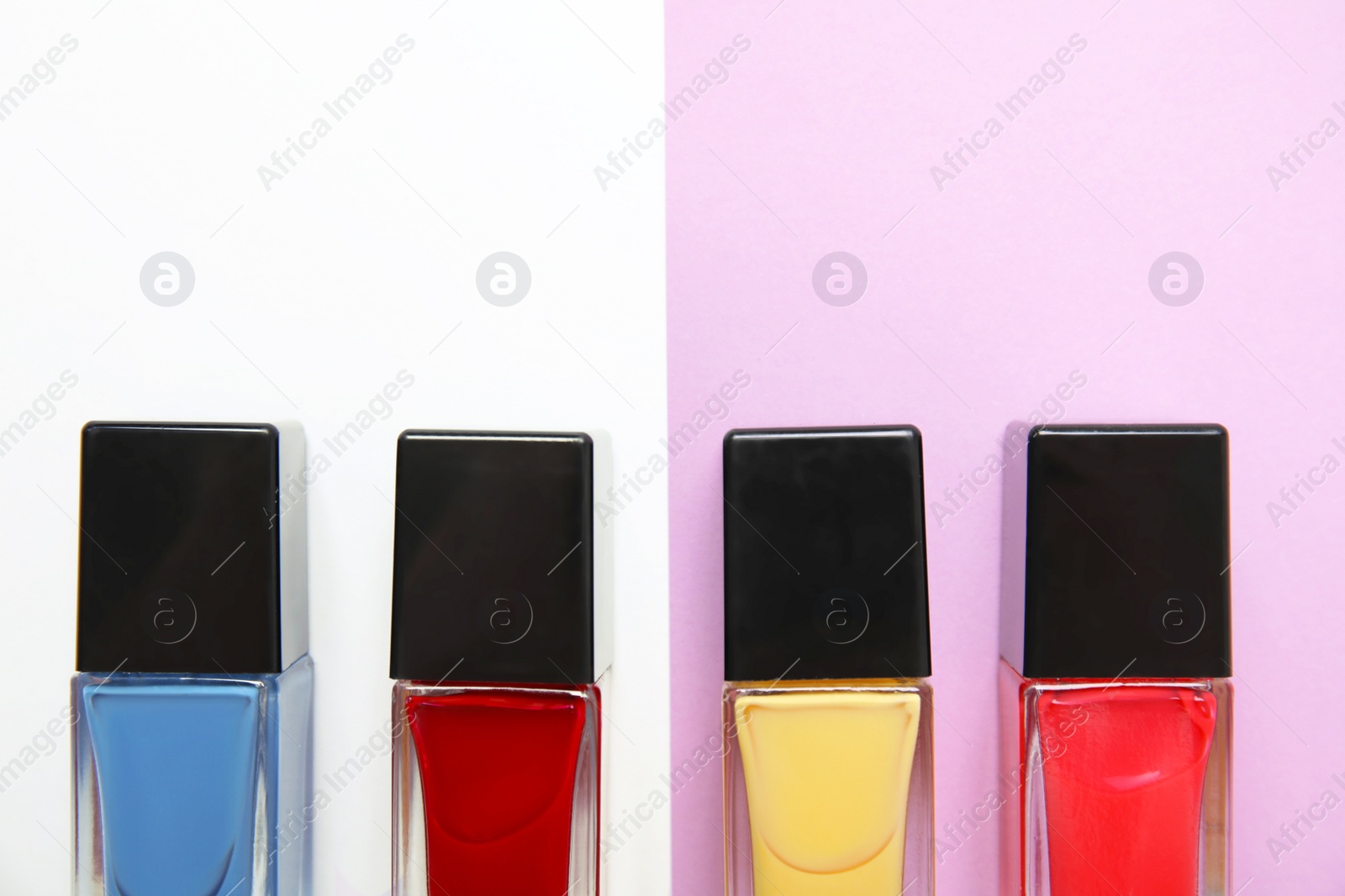 Photo of Bottles of nail polish on color background, top view with space for text