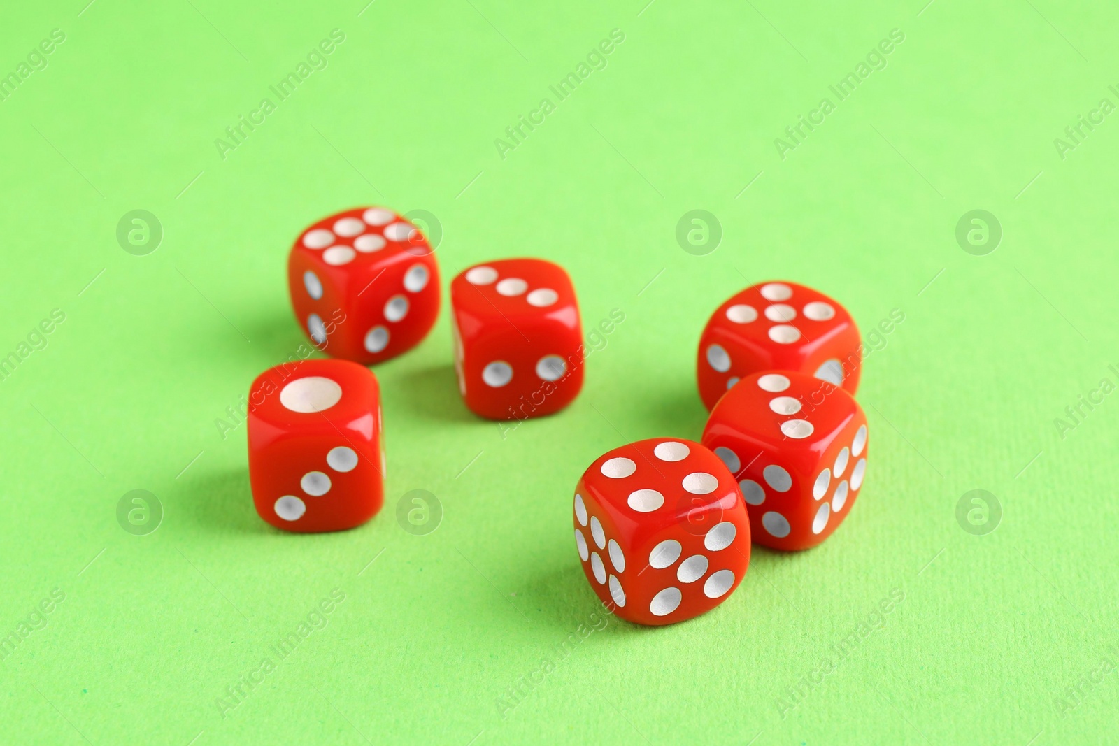 Photo of Many red game dices on green background