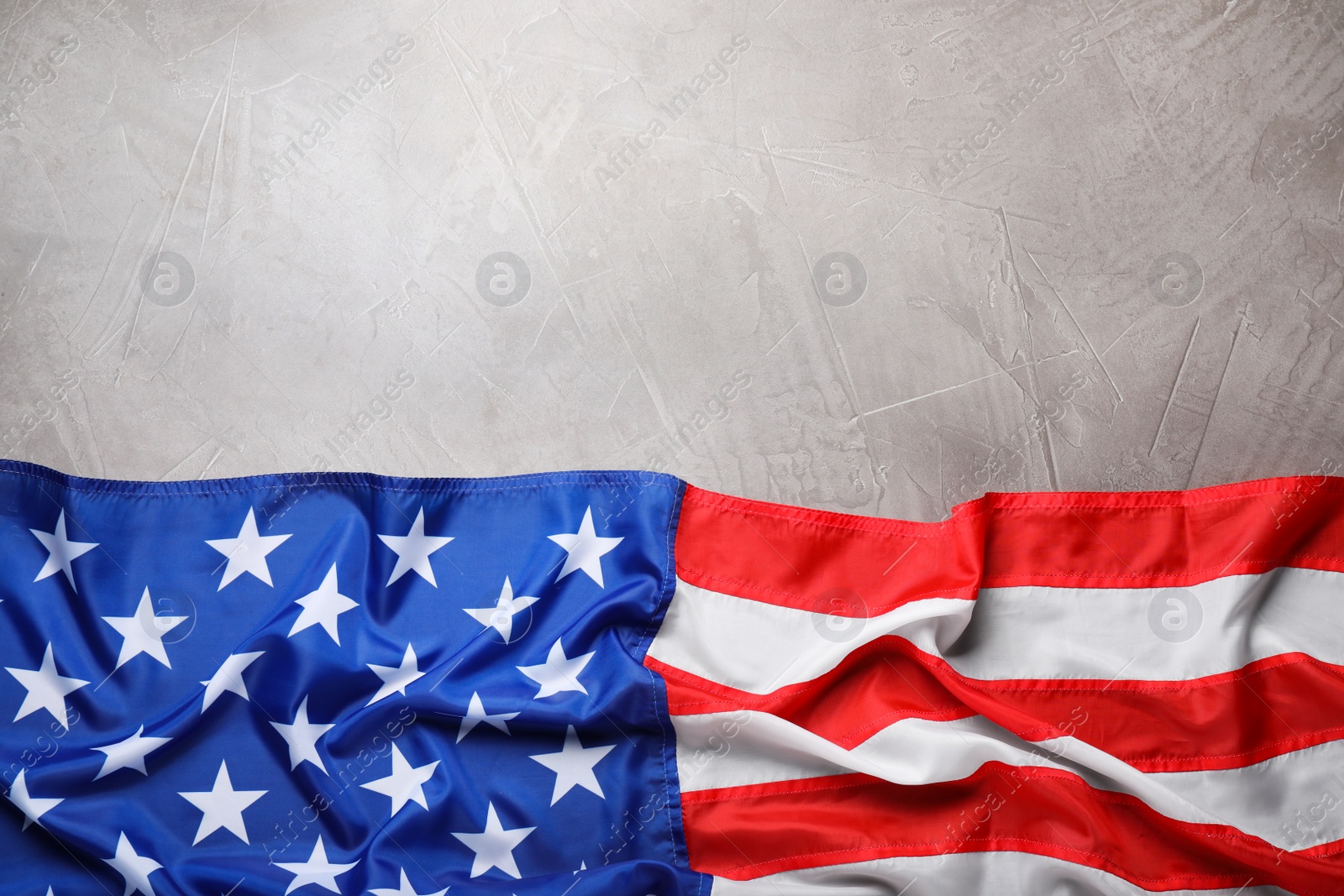Photo of American flag on light grey background, top view. Space for text