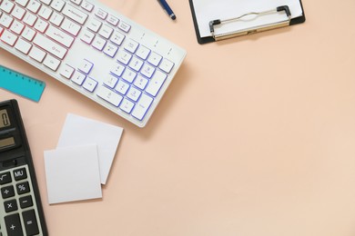 Modern keyboard with RGB lighting and stationery on light pink background, flat lay. Space for text