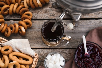 Photo of Flat lay composition with delicious ring shaped Sushki (dry bagels) and cup of tea on wooden table