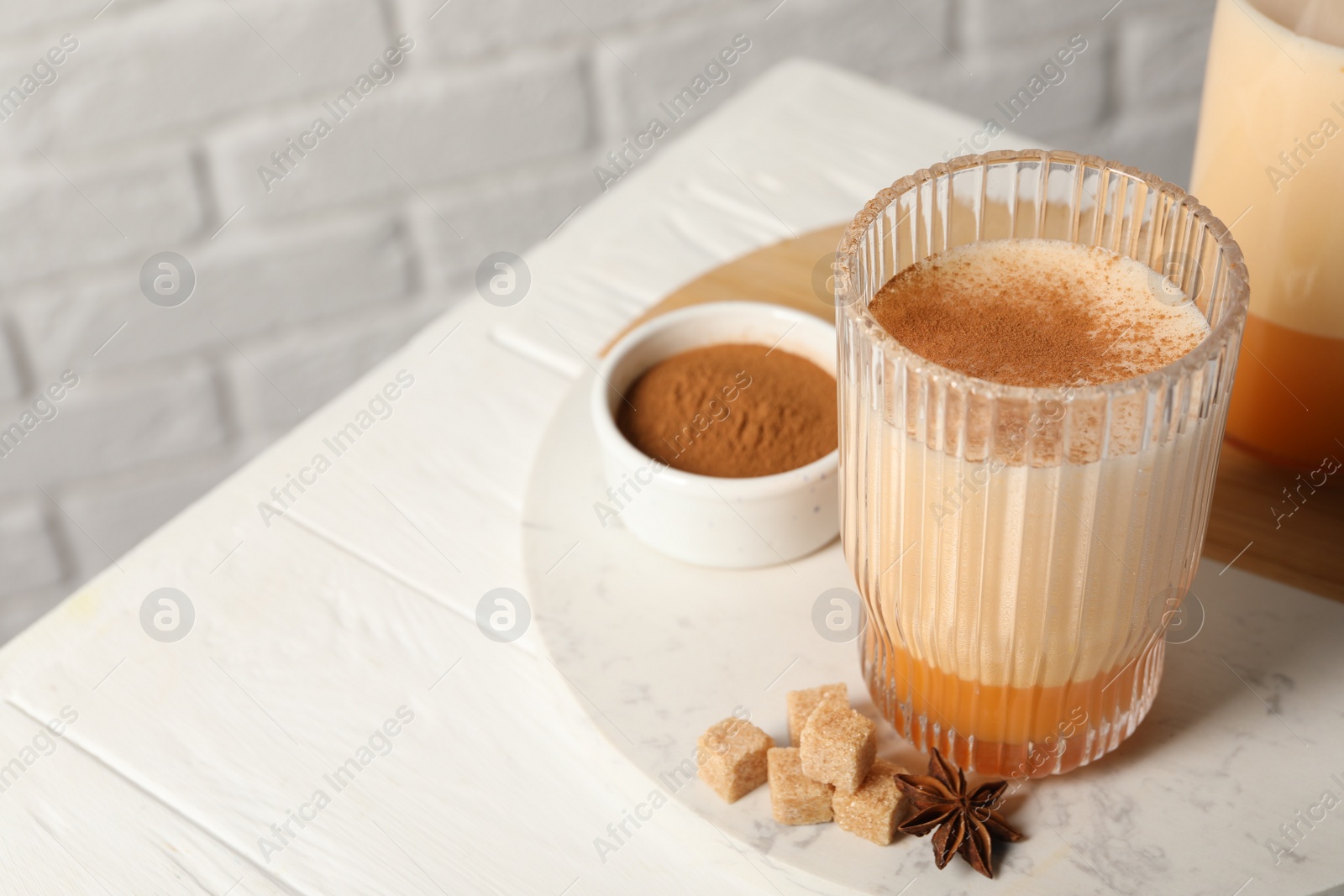 Photo of Delicious eggnog with anise and sugar on white wooden table. Space for text