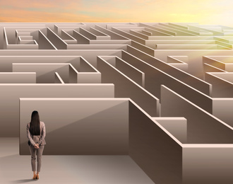 Young businesswoman trying to find way out of maze