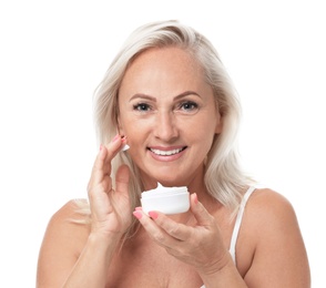 Portrait of beautiful mature woman with perfect skin holding jar of cream on white background