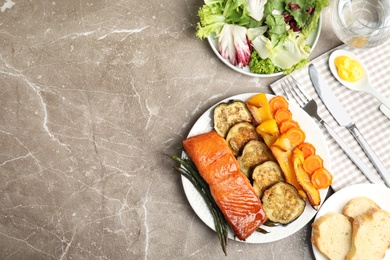 Photo of Delicious cooked salmon and vegetables served on grey table, flat lay with space for text. Healthy meals from air fryer