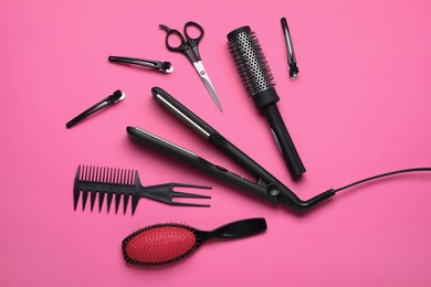 Photo of Flat lay composition of different professional hairdresser tools on pink background