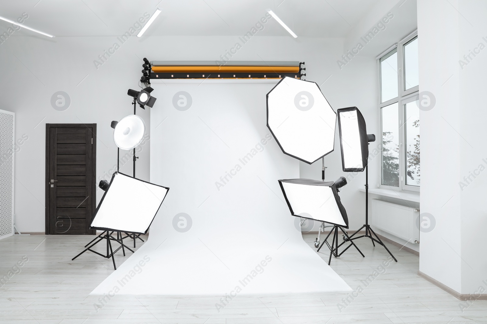 Photo of Interior of modern photo studio with professional lighting equipment