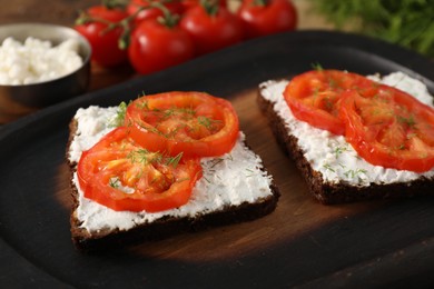 Photo of Delicious ricotta bruschettas with sliced tomatoes and dill on wooden table, closeup