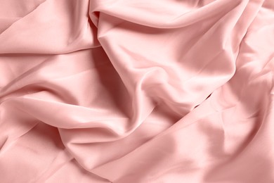 Pale pink shiny fabric as background, top view