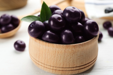 Tasty acai berries in bowl on white table, closeup