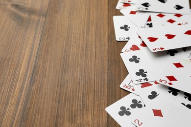 Playing cards on wooden table, space for text