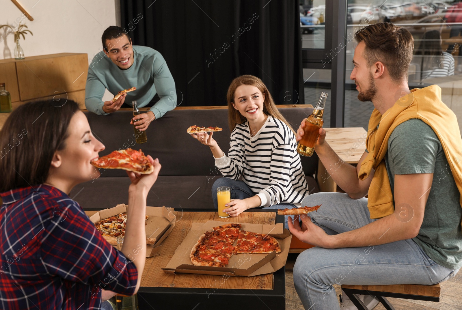 Photo of Group of friends having fun party with delicious pizza in cafe