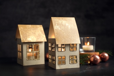 Photo of Composition with house shaped candle holders on dark background. Christmas decoration