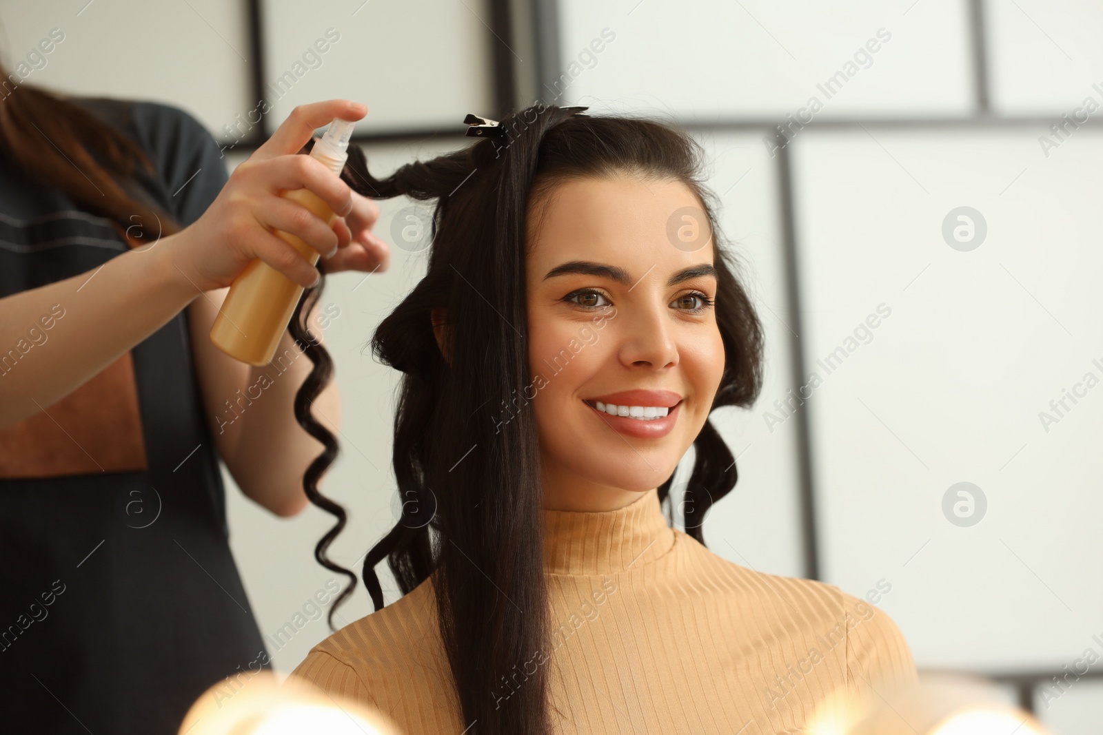 Photo of Hair styling. Professional hairdresser working with smiling client in salon, closeup