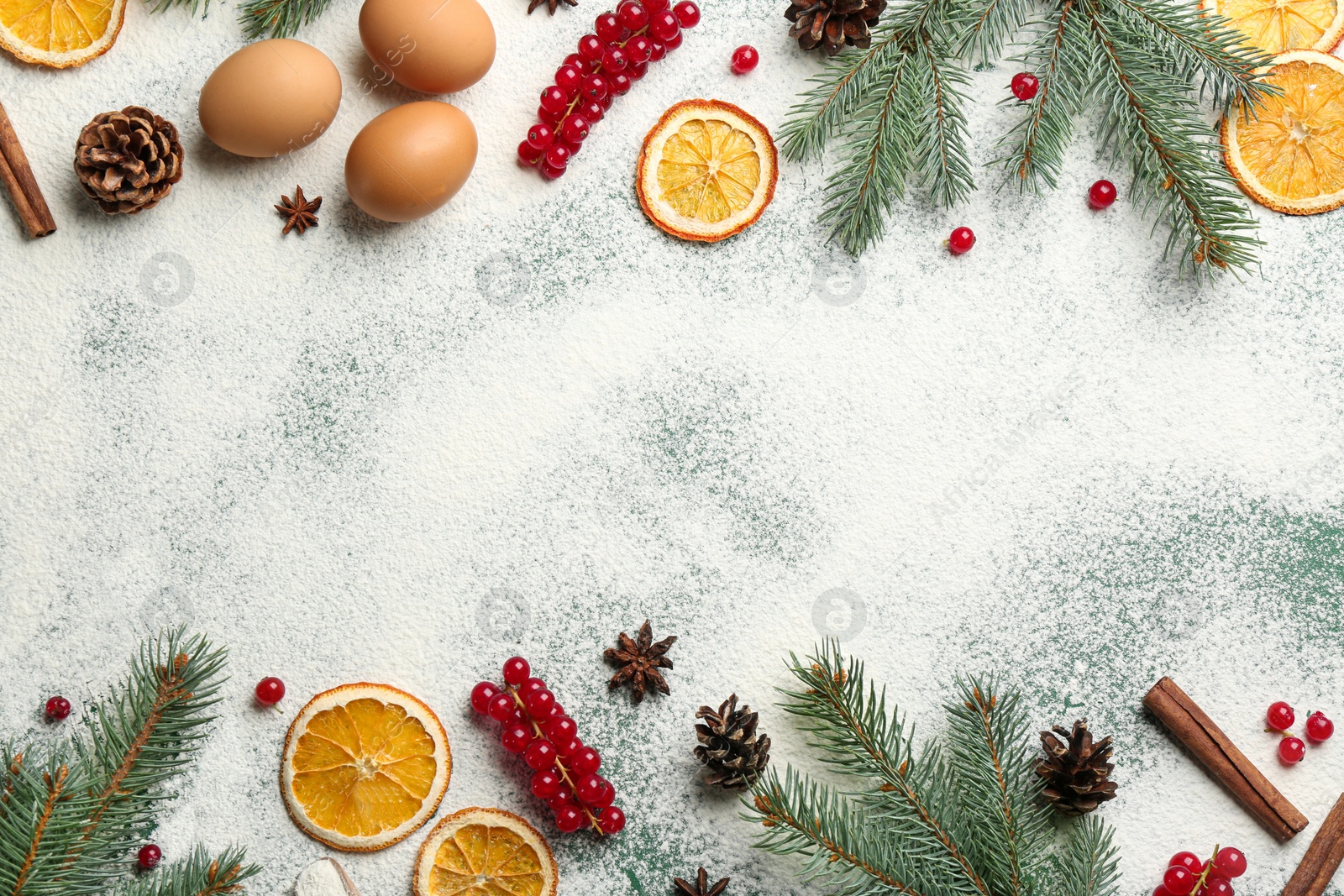 Photo of Frame of Christmas decor and flour on green background, flat lay. Space for text