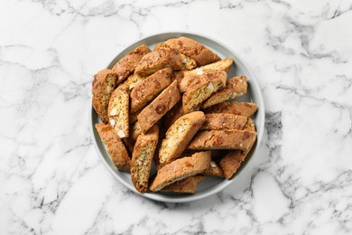 Photo of Traditional Italian almond biscuits (Cantucci) on white marble table, top view