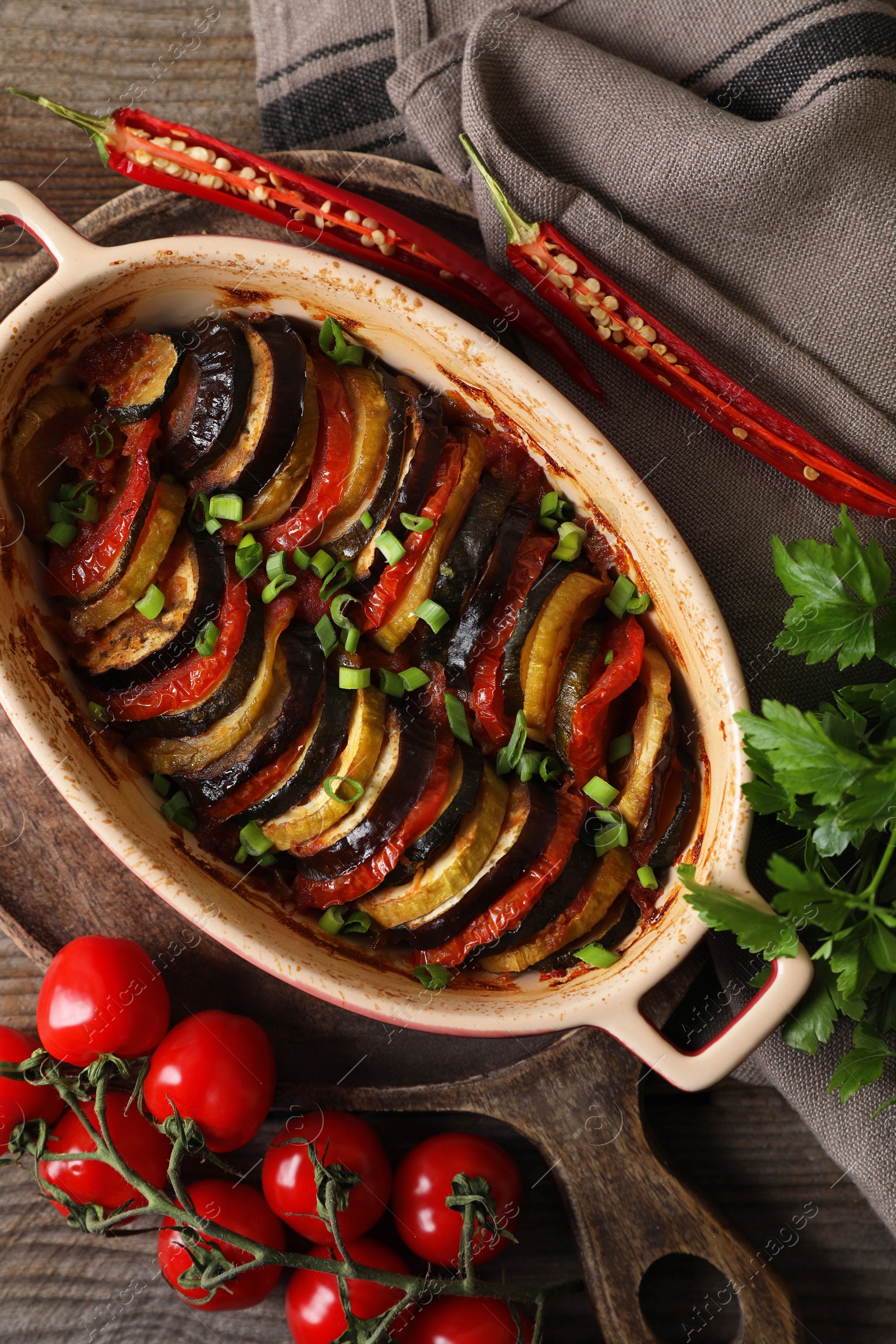 Photo of Delicious ratatouille and ingredients on table, flat lay