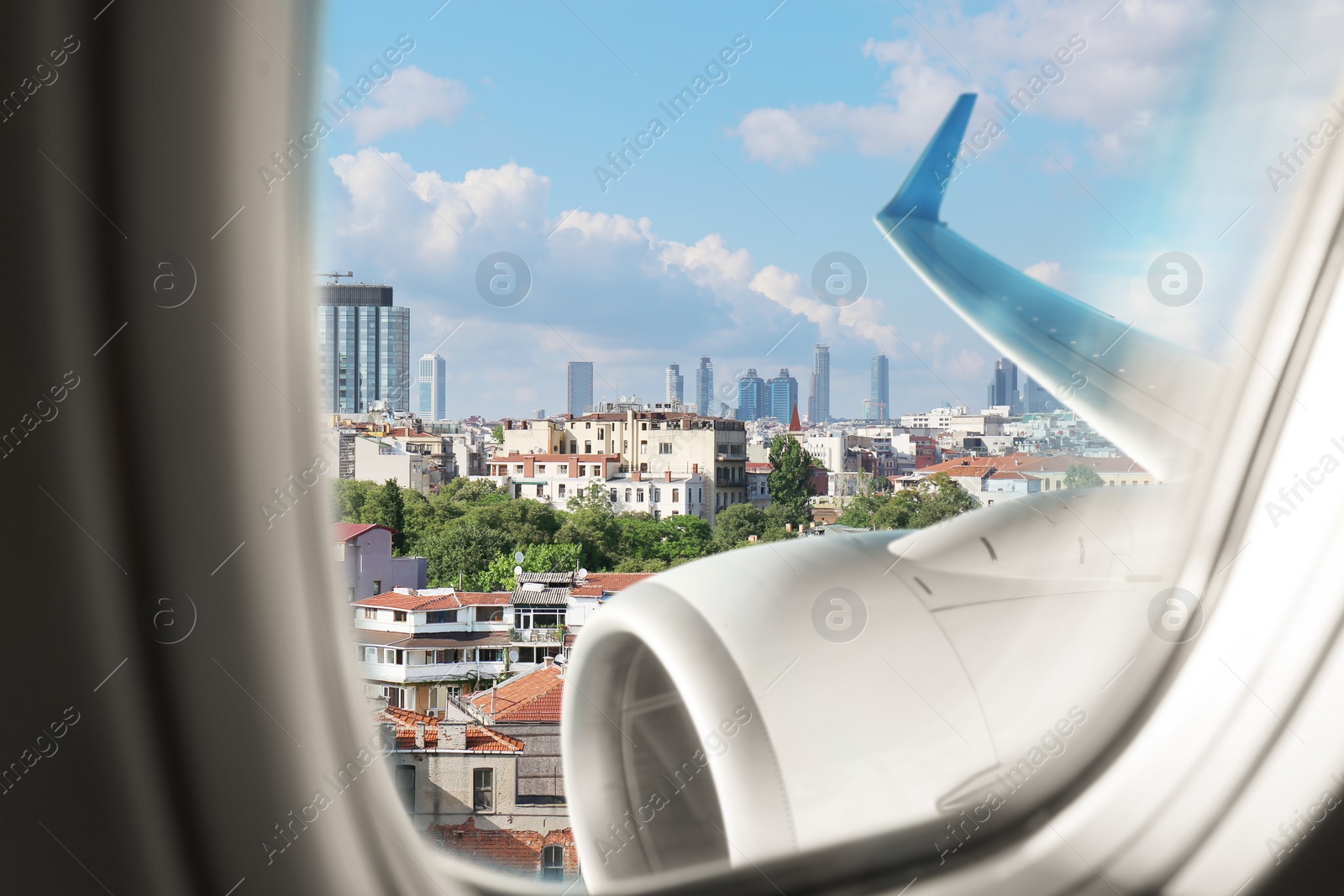 Image of Beautiful view of city with buildings through airplane window during flight