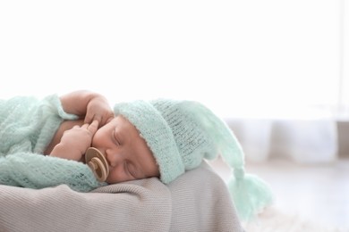 Photo of Cute newborn baby in warm hat sleeping on plaid. Space for text
