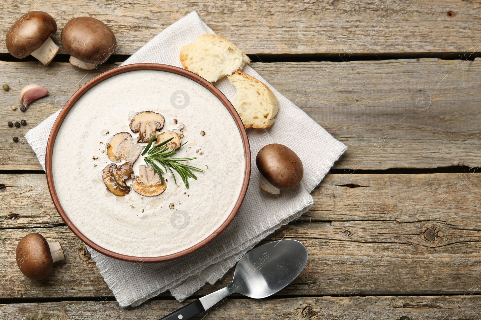 Photo of Fresh homemade mushroom soup served on wooden table, flat lay. Space for text