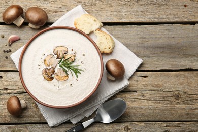 Photo of Fresh homemade mushroom soup served on wooden table, flat lay. Space for text