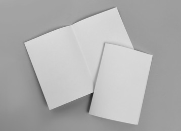 Blank paper brochures on light grey background, flat lay. Mockup for design
