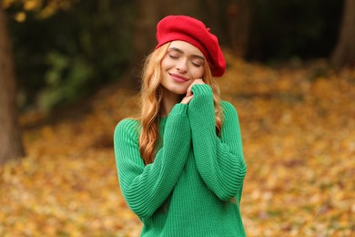 Beautiful woman wearing warm sweater in autumn park