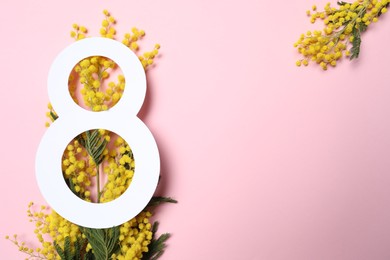 Photo of 8 March greeting card design with yellow mimosa flowers on pink background, top view. Happy International Women's Day