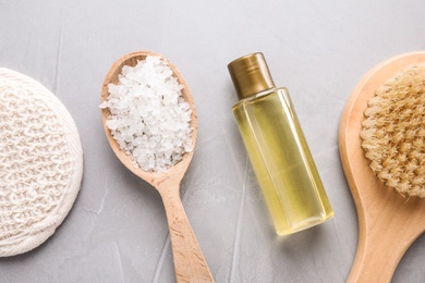 Photo of White sea salt and supplies for spa scrubbing procedure on wooden table, flat lay