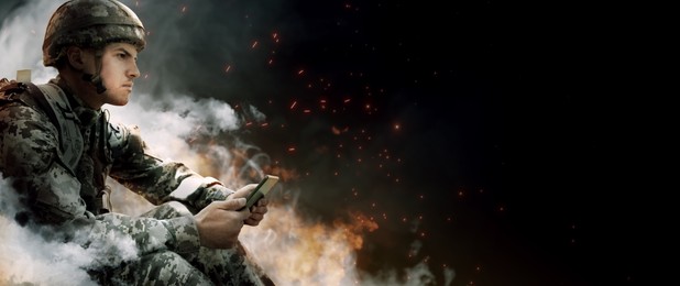 Image of Armed soldier using tablet in smoke on black background, space for text. Banner design