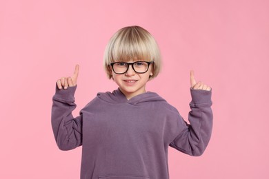 Photo of Cute little boy wearing glasses on pink background