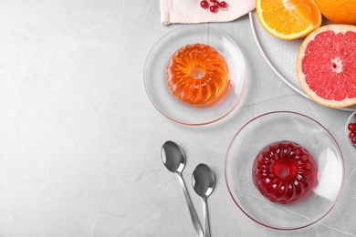 Flat lay composition with fruit jelly on light grey table. Space for text