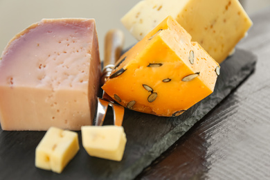 Photo of Different types of delicious cheeses on wooden table, closeup