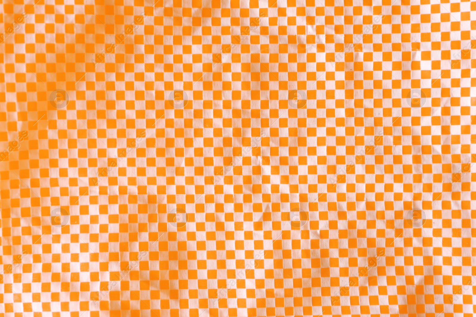 Photo of Texture of orange and white checkered fabric as background, top view