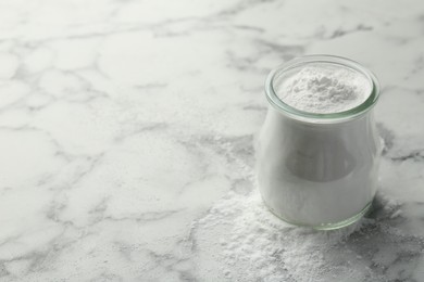 Baking powder in jar on white marble table, space for text