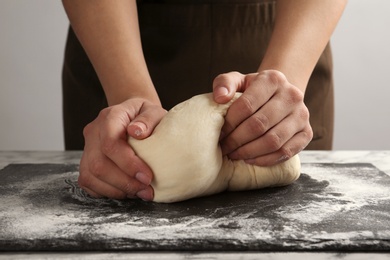 Photo of Female baker preparing bread dough at table, closeup