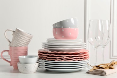 Photo of Beautiful ceramic dishware, glasses, cups and cutlery on white marble table