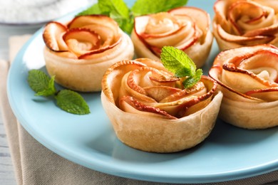 Freshly baked apple roses on plate, closeup. Beautiful dessert