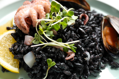 Photo of Delicious black risotto with seafood, closeup view