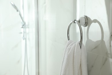 Photo of Holder with clean towel on light wall in bathroom. Space for text