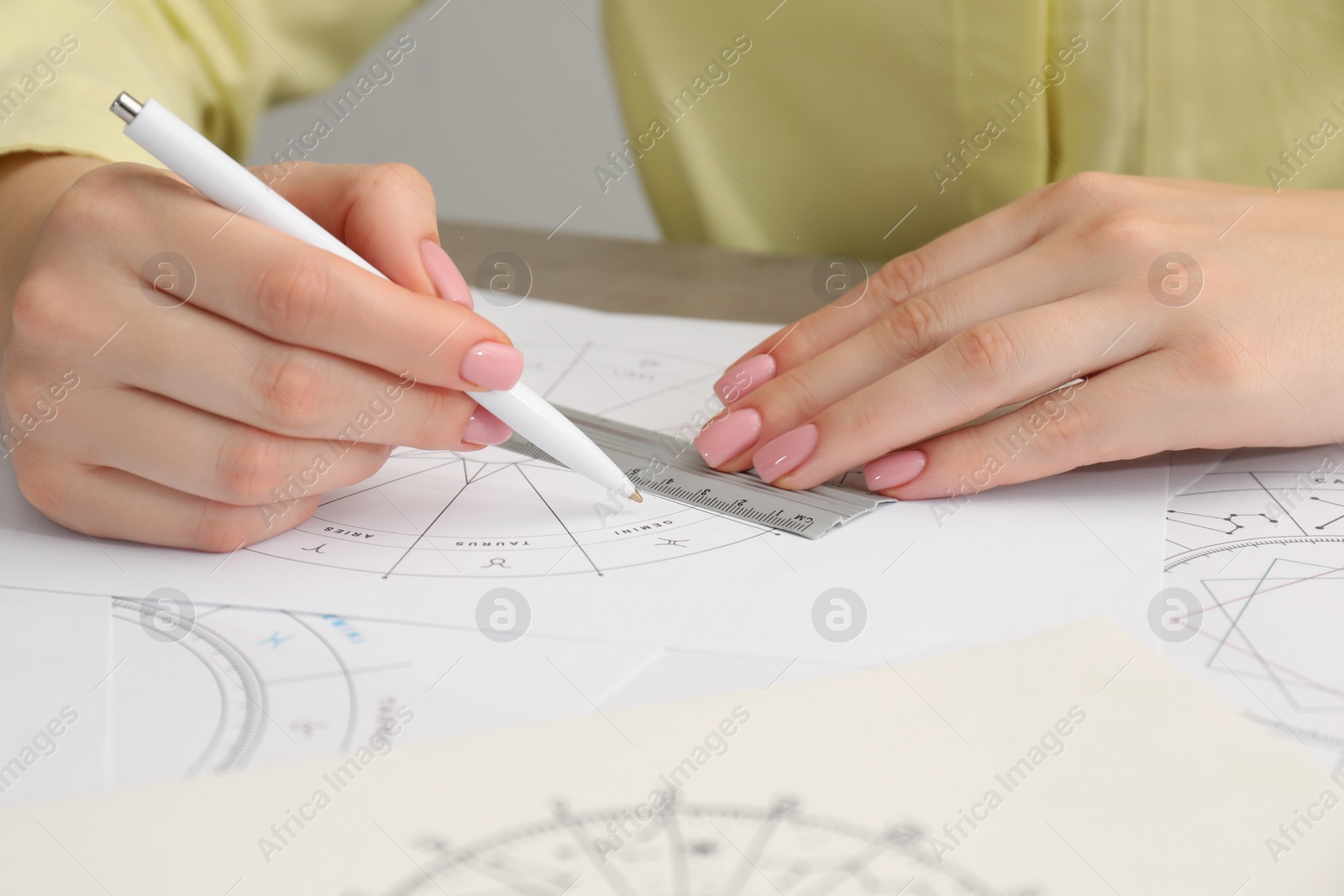 Photo of Astrologer using zodiac wheel for fate forecast at table, closeup. Fortune telling