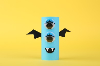 Photo of Spooky paper monster on yellow background. Halloween decoration