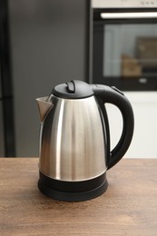 Photo of Modern electric kettle on table in kitchen