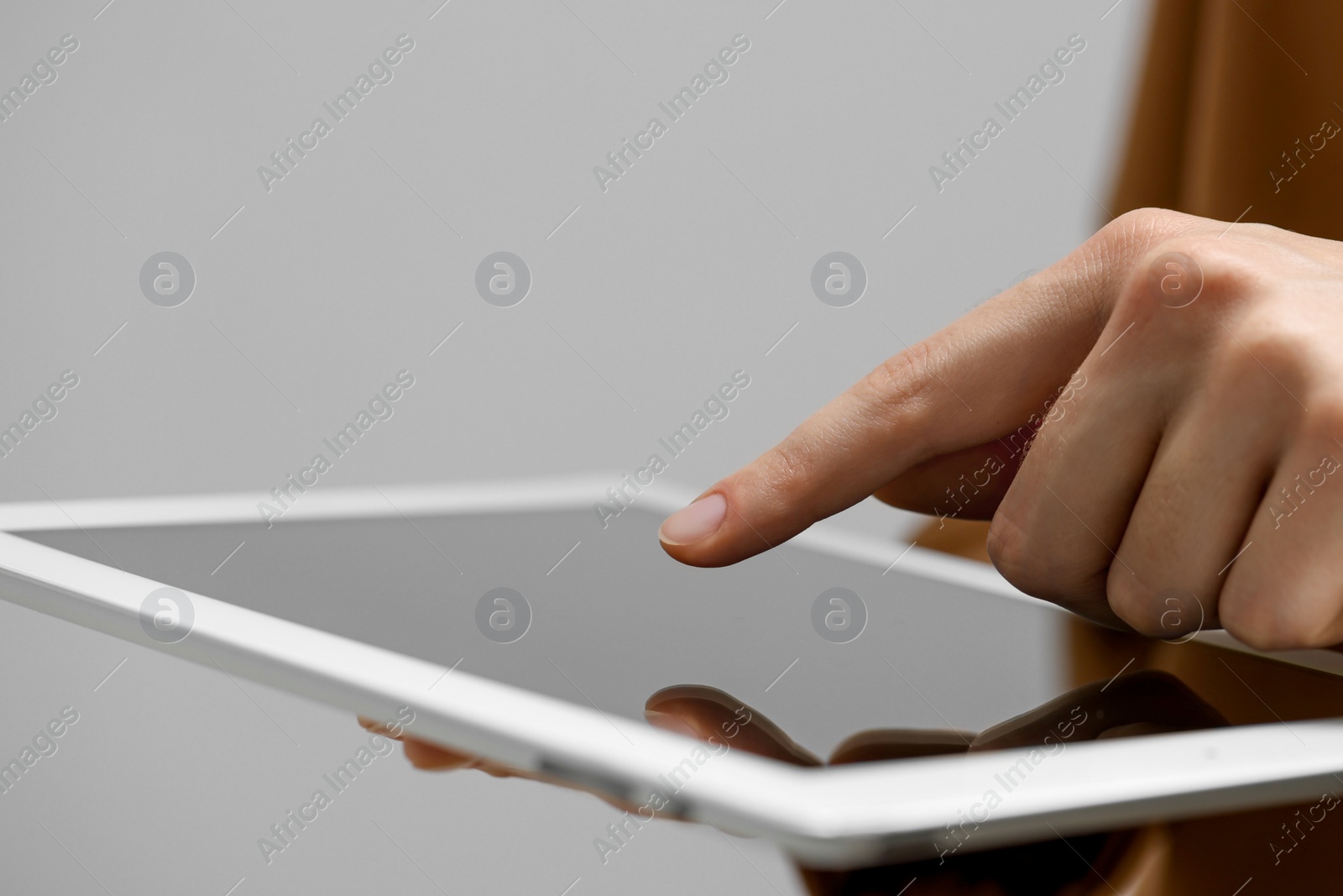 Photo of Closeup view of woman using modern tablet on grey background