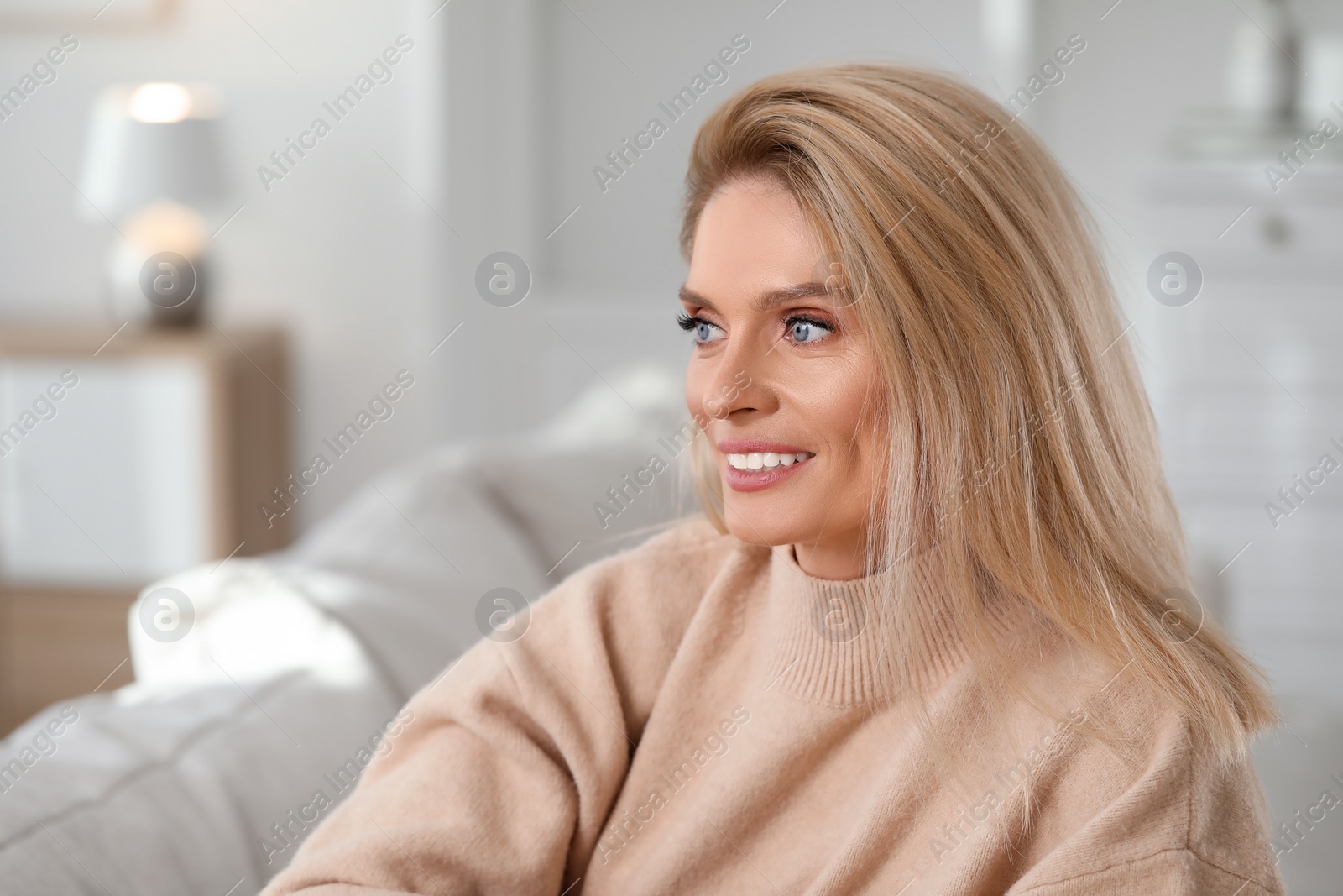 Photo of Portrait of smiling middle aged woman with blonde hair indoors