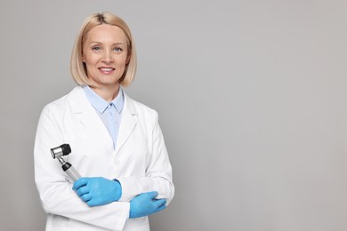 Happy dermatologist with dermatoscope on grey background, space for text