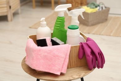 Photo of Different cleaning products in wooden box on table indoors